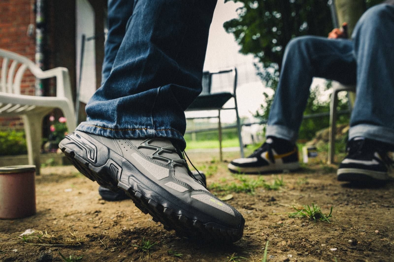 Nahaufnahme grauer Chunky-Sneaker auf Kopfsteinpflaster