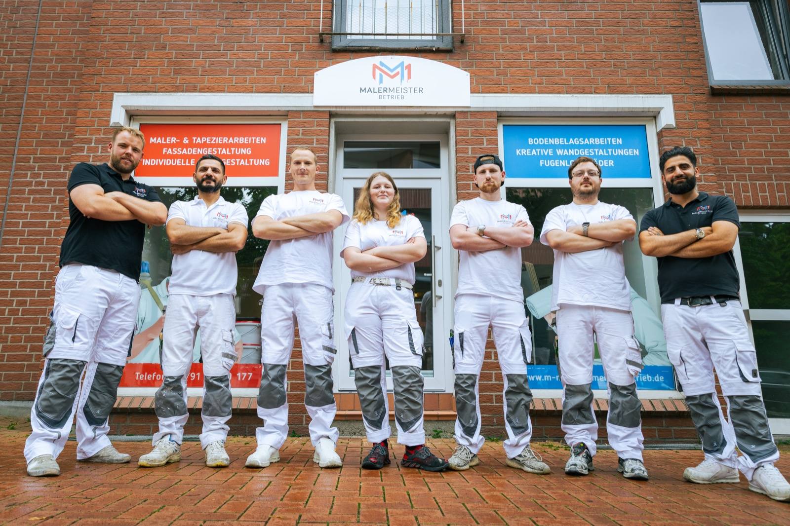 Siebenköpfiges Team des Malermeister Betriebs vor dem Firmengebäude